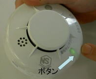 写真：住宅用火災警報器のボタンを押してテストをしている様子