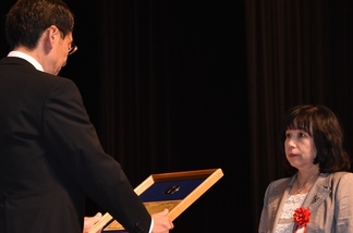 写真：一般表彰者を代表して表彰状を受け取る 天野博子さん
