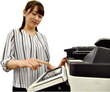 写真：コンビニで証明書を取る女性