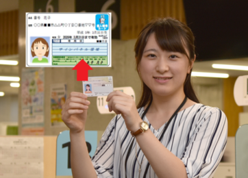 写真：マイナンバーカードを持った女性職員