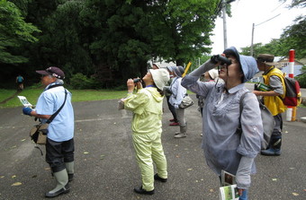 写真：双眼鏡を使っている人々