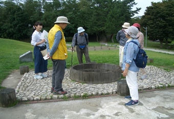 写真：天平の井戸の説明を受けている様子