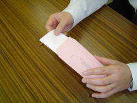 写真：投票用紙を内封筒へ入れる